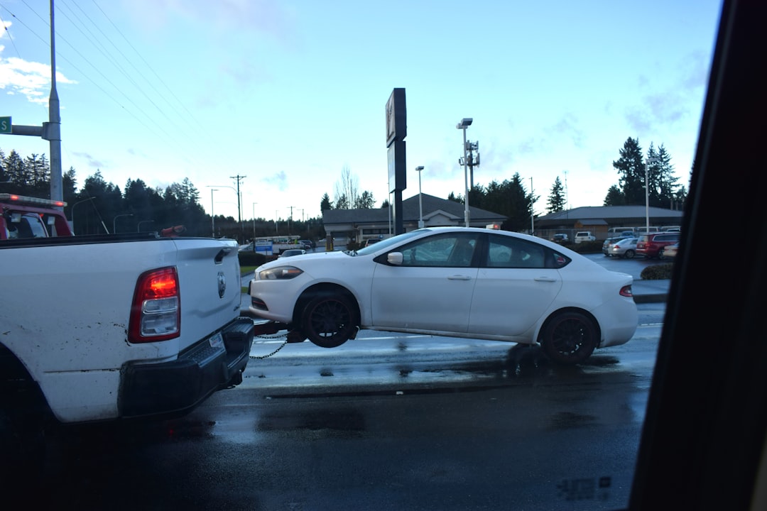 a-white-car-being-towed-by-a-tow-truck-mok9wrwyggg
